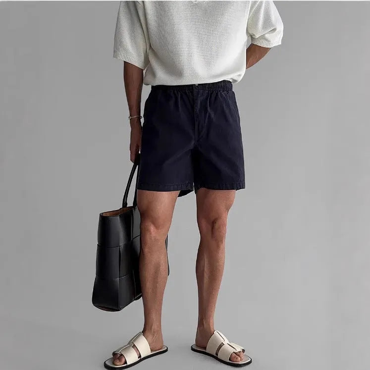 Man's loose-fit cotton sports shorts in khaki colour on a white background.