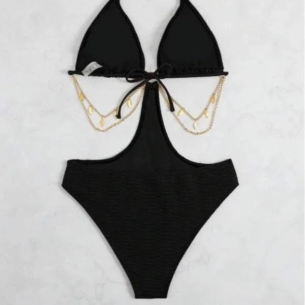 Women's black bikini swimsuit with gold chain detail on a model.