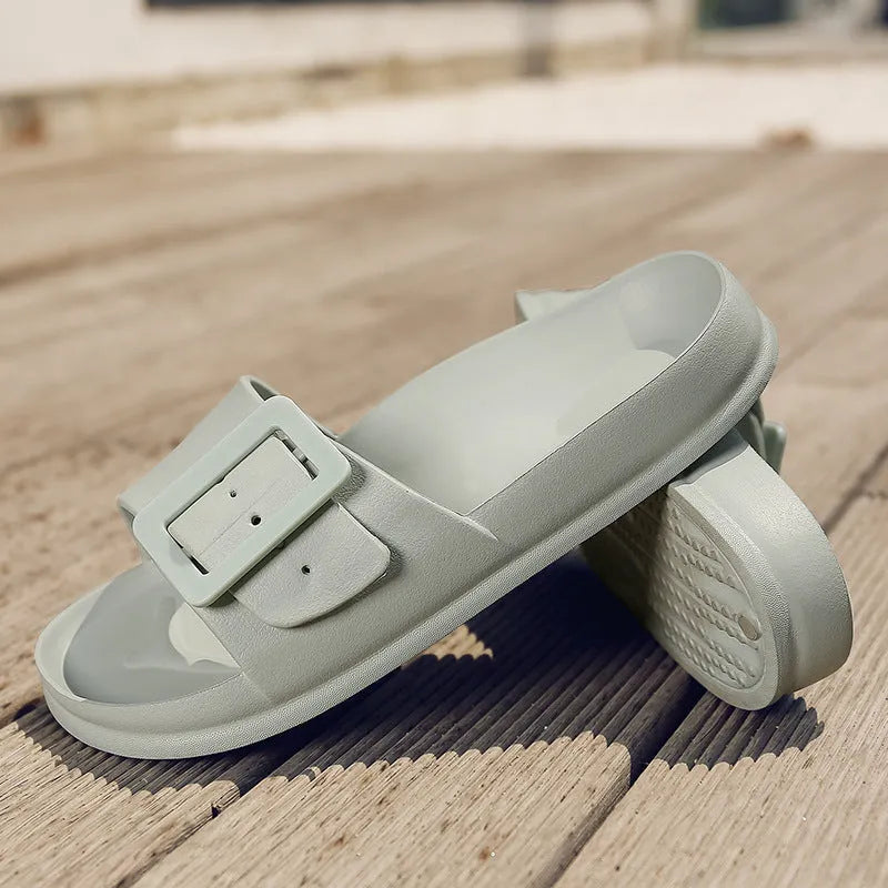 Women's grey blue buckle slippers with a flip-flop design and soft EVA sole on a white background