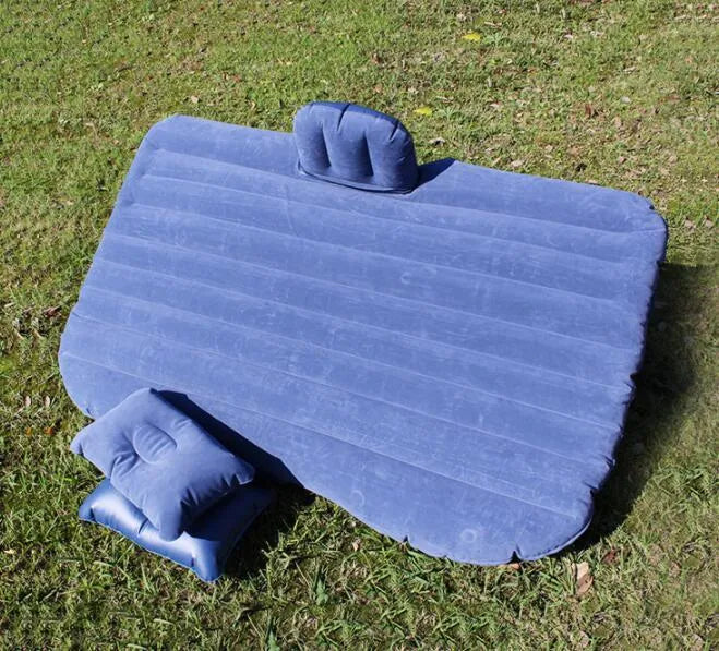 Black inflatable car bed with flocking surface and two pillows, shown folded next to a storage bag.