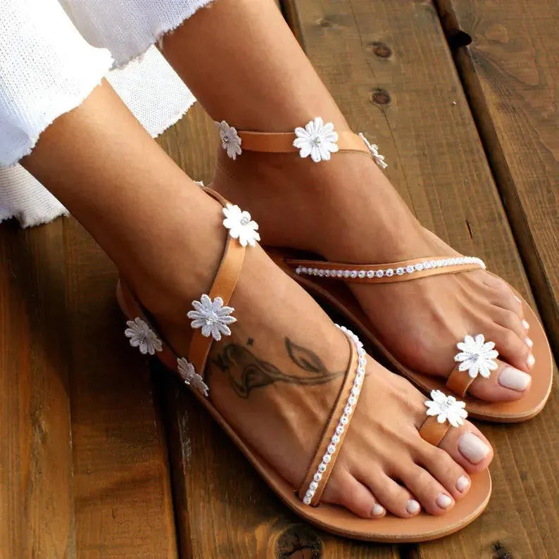 Brown flat-bottom Roman sandals with flower pattern and herringbone toe design