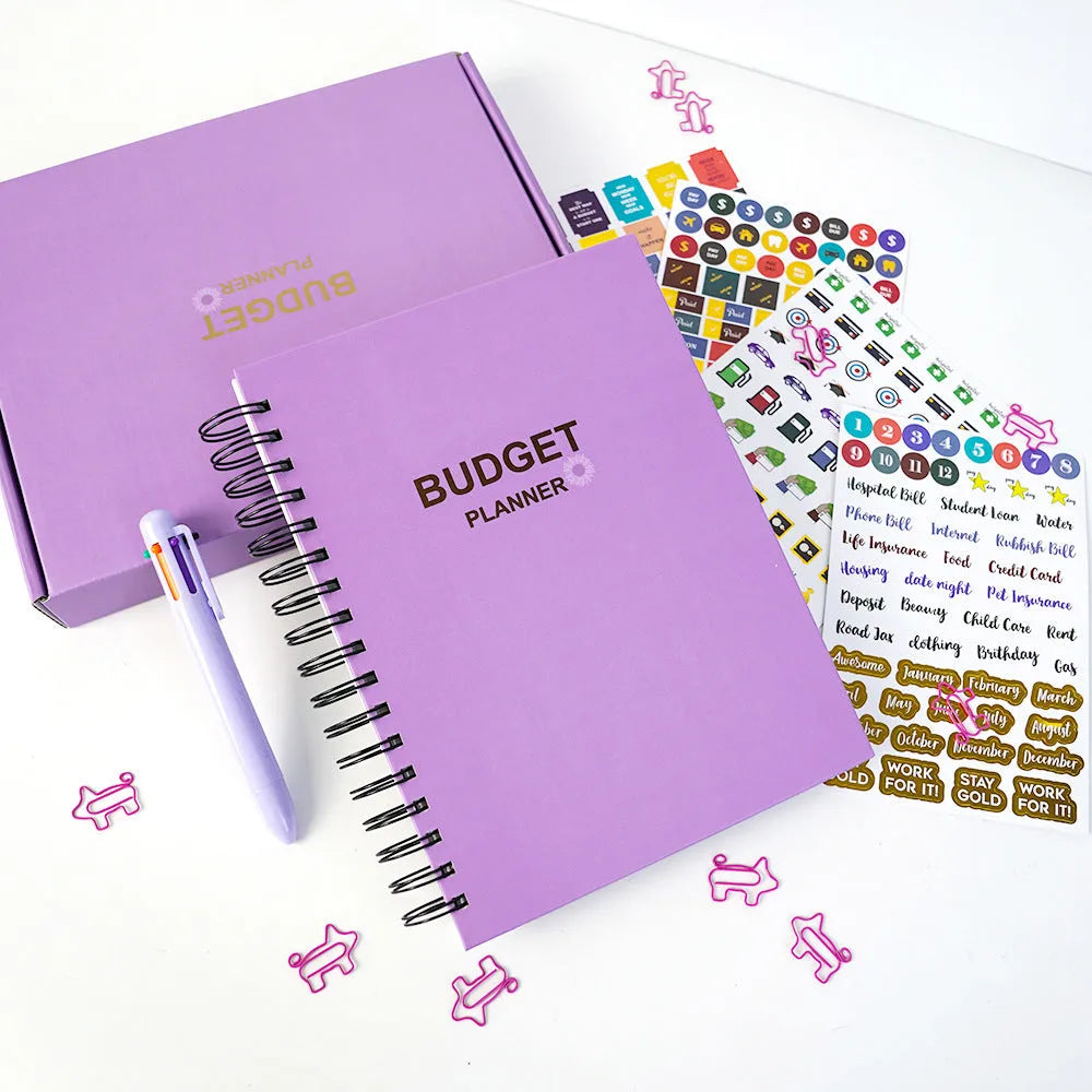 Purple coil-bound financial planning notebook with budget stickers and paper clips
