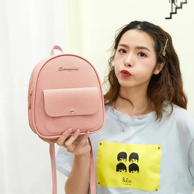 Women's black PU backpack purse with letter design and shoulder strap showing compact 18.5cm length