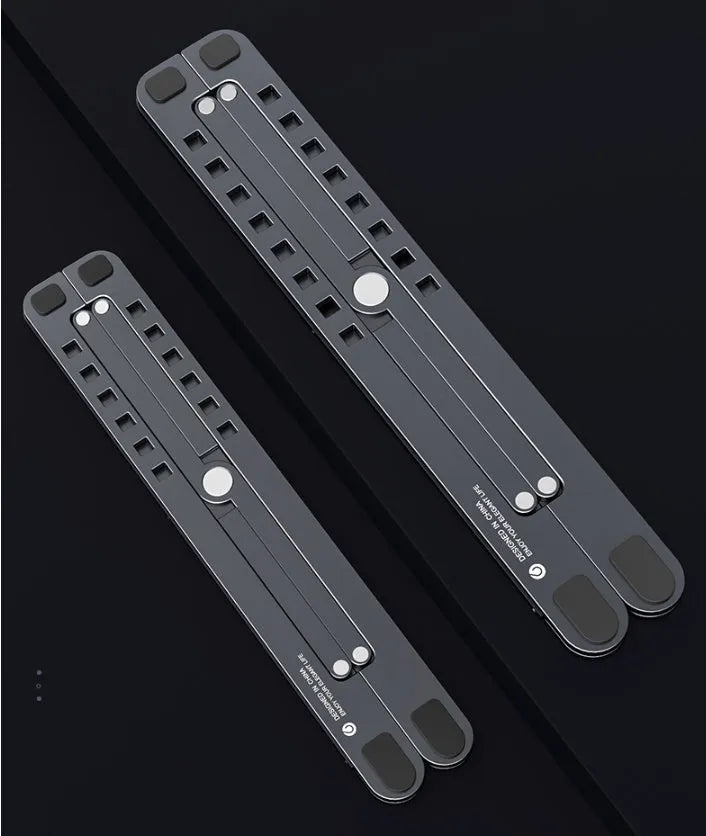 Aluminium laptop stand in silver colour, folded flat next to an open laptop for size comparison.
