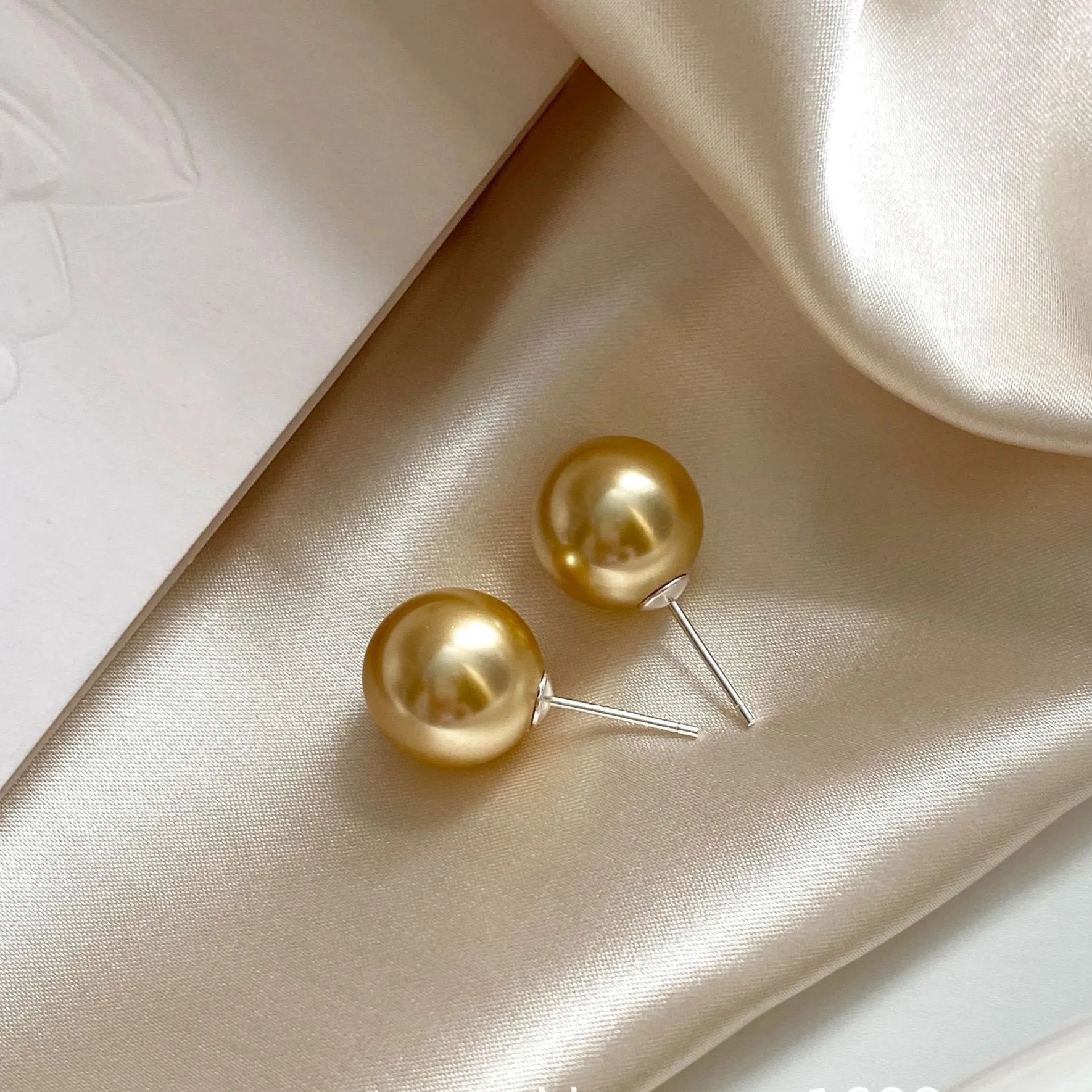 Women's large pearl stud earrings with an eight-pointed star geometric setting in sterling silver.