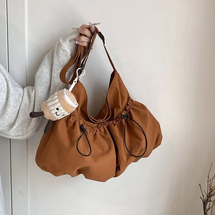 Soft green pleated foldable crossbody bag showing split pocket and internal mobile phone compartment