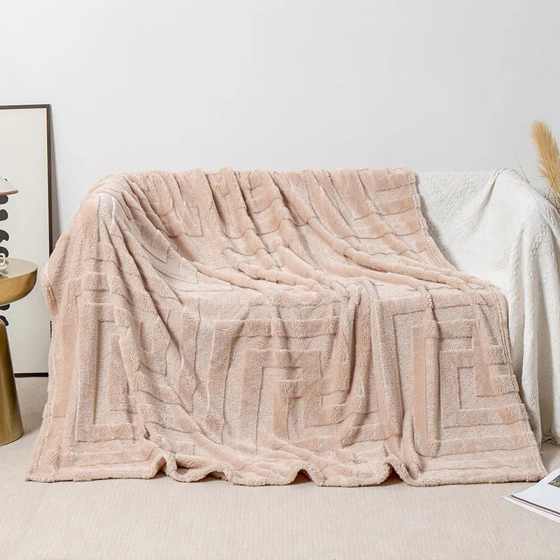Thick coral fleece sofa blanket in a choice of colours and sizes draped over a grey sofa