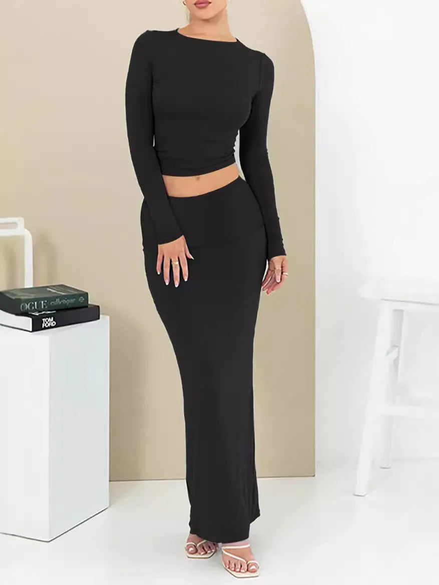 Women's black slim fit two-piece suit set with three-quarter sleeve top and long skirt on a model.