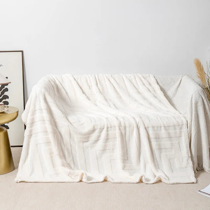 Thick coral fleece sofa blanket in a choice of colours and sizes draped over a grey sofa