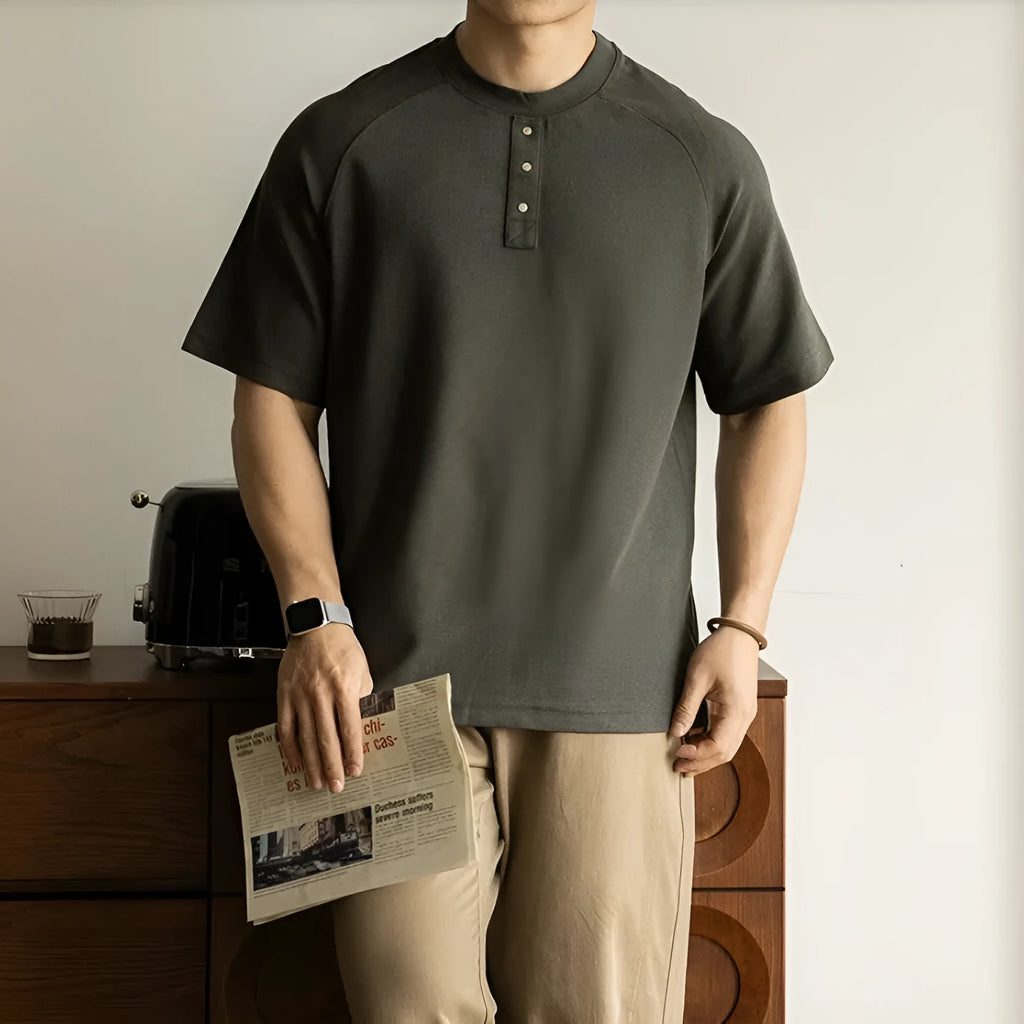 Women's loose grey casual pullover top with raglan sleeves on a hanger.