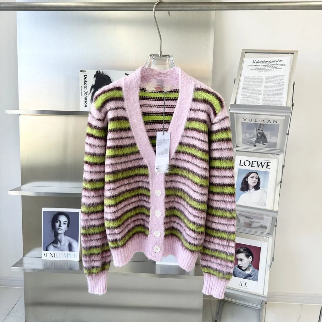 Pink women's wool knitted cardigan and round-neck pullover sweater with contrast details on a hanger.