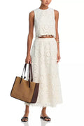 White women's two-piece suit with sleeveless top, long skirt, and embroidery detail.