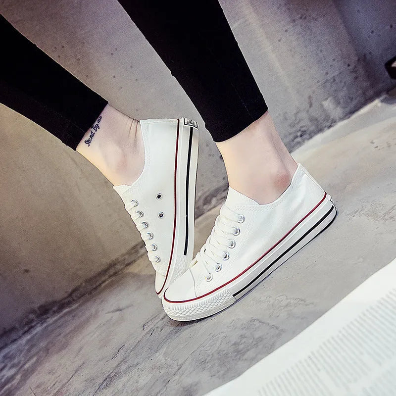 Women's solid colour canvas slip-on shoes in black, white, and red variations on a plain background.
