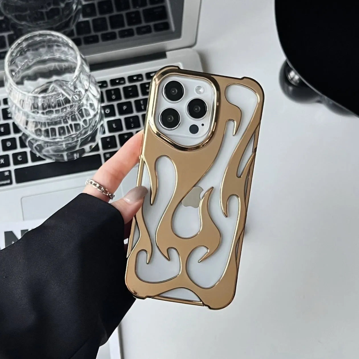 Electroplated hollow flame pattern TPU iPhone case in silver plating shown on a phone.