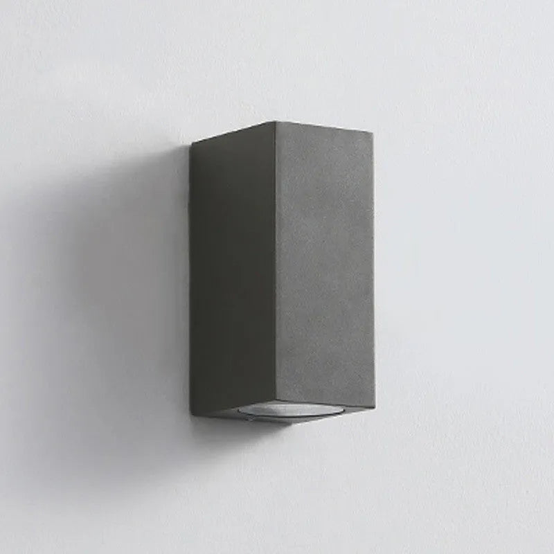 Satin black aluminium and glass LED wall lamp mounted on an interior wall.