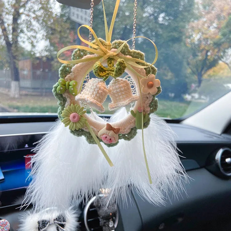 Handmade woven wool bell orchid car pendant on a green background, showing textured detail.