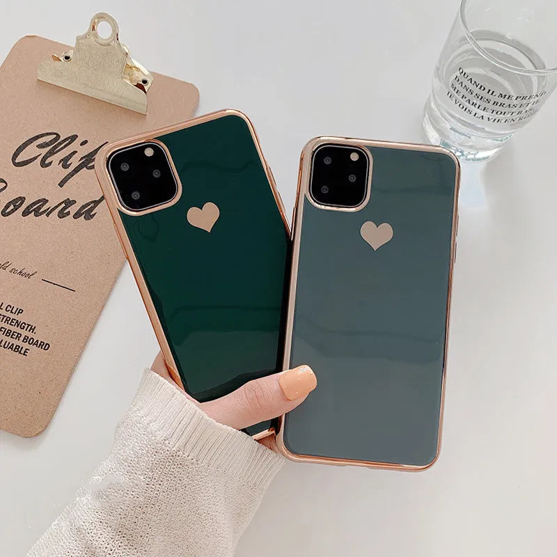 TPU iPhone case with solid colour and a raised metallic love heart design on the back.
