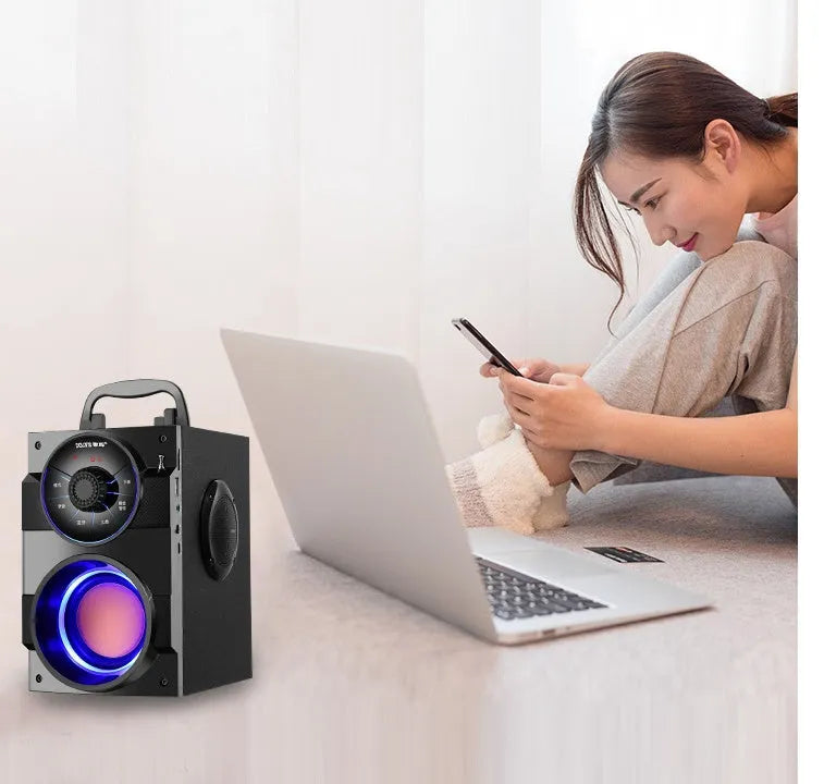 Black portable mini home audio system with subwoofer, satellite speakers, and a connected USB charging cable.