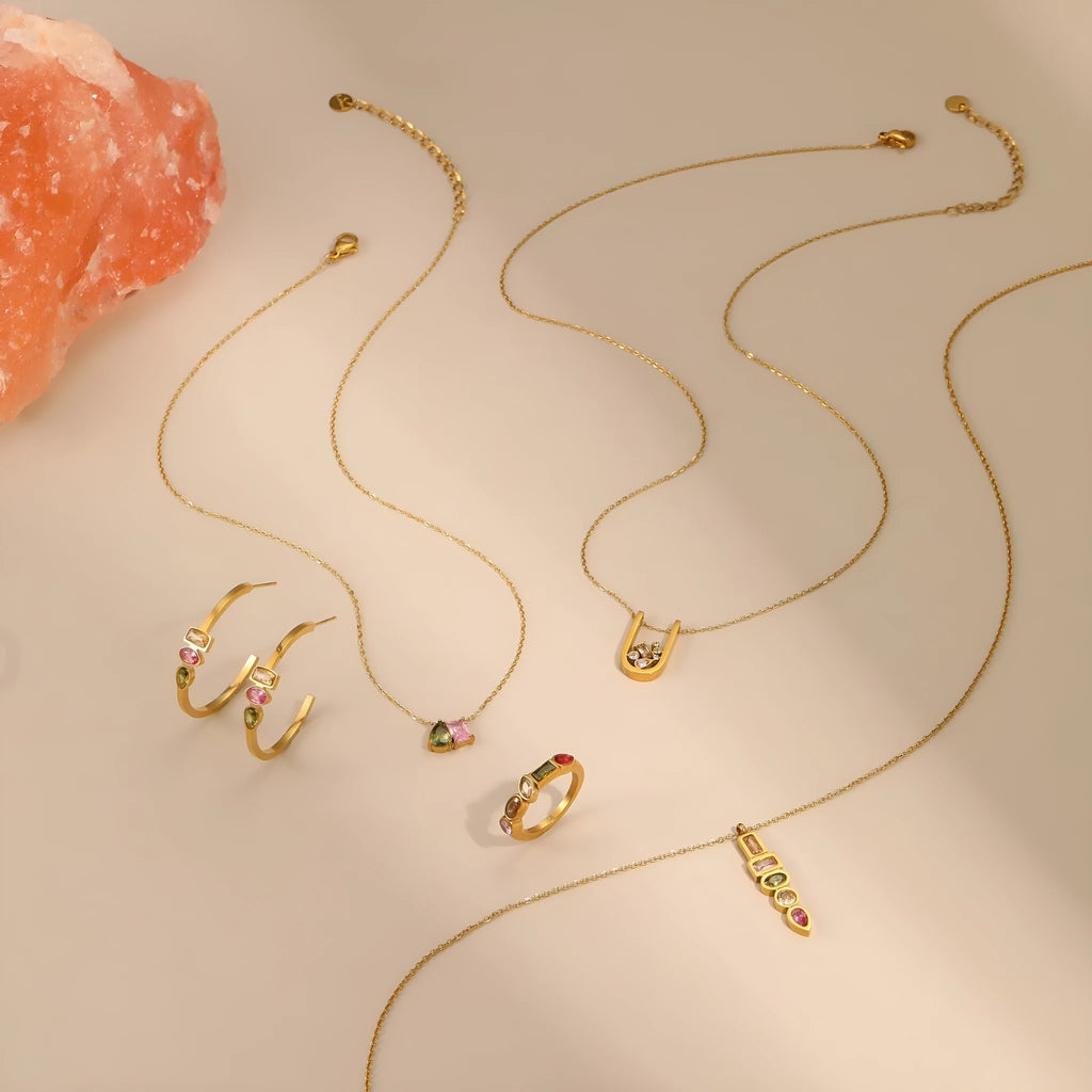 Geometric gold plated jewellery set showing necklace, ring, and earrings with chain-style design
