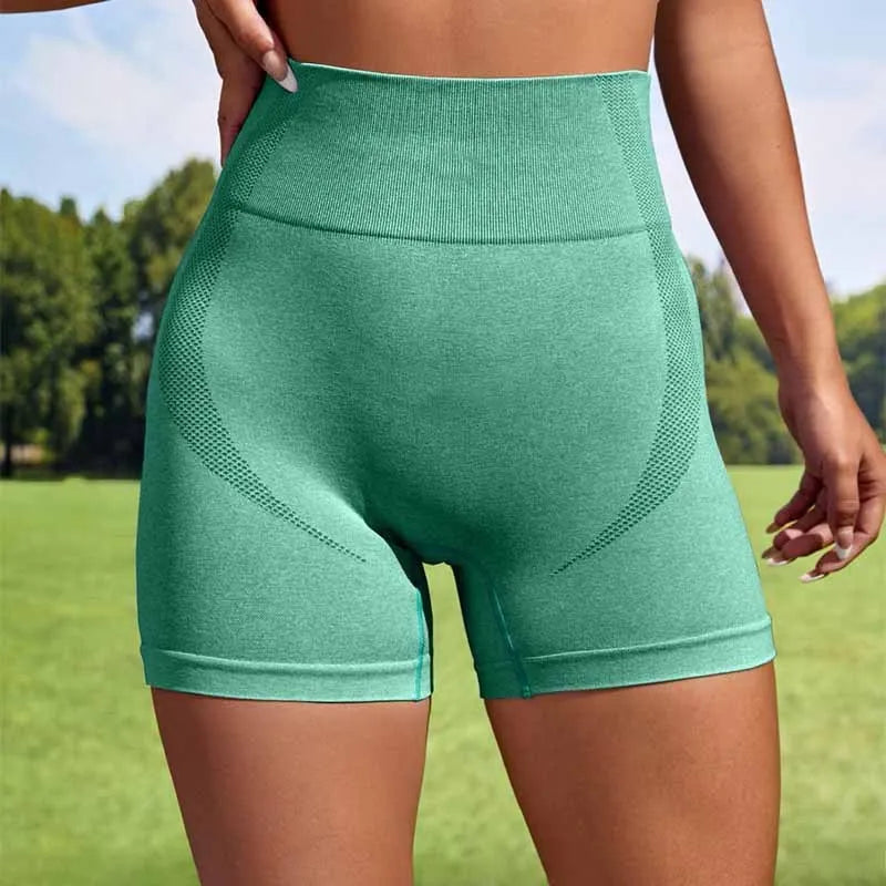 Women's seamless high-waist fitness short leggings in a solid colour, shown in a stretch pose.