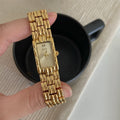 Women's bracelet-style watch with 15mm dial, silver stripe strap, and butterfly clasp