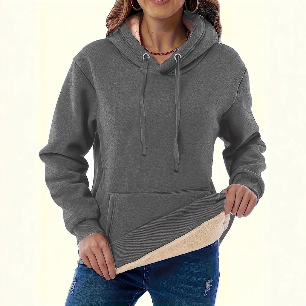 A women's loose fit hooded sweater in thick grey polyester with side pockets and long sleeves.