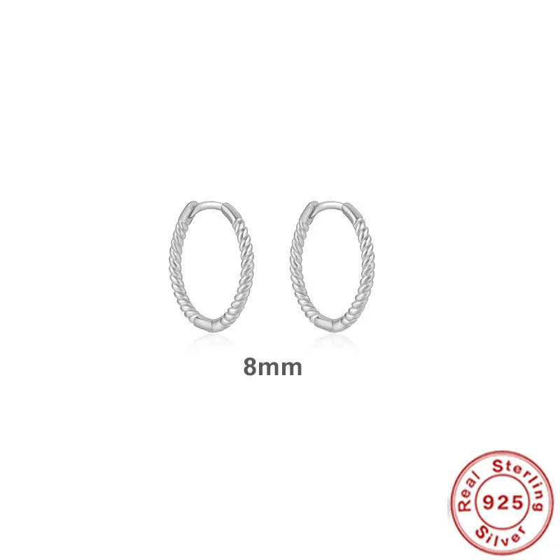 A pair of twisted sterling silver round earrings in a geometric design on a white background.