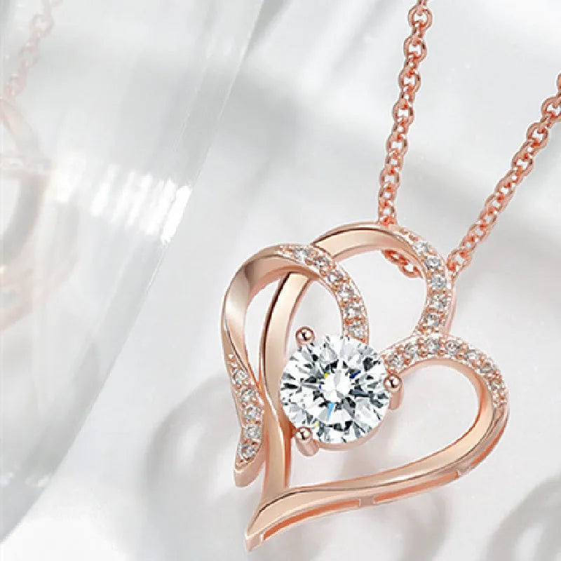 Women's heart-shaped silver necklace shown in rose gold, white gold, and yellow gold plating variations.
