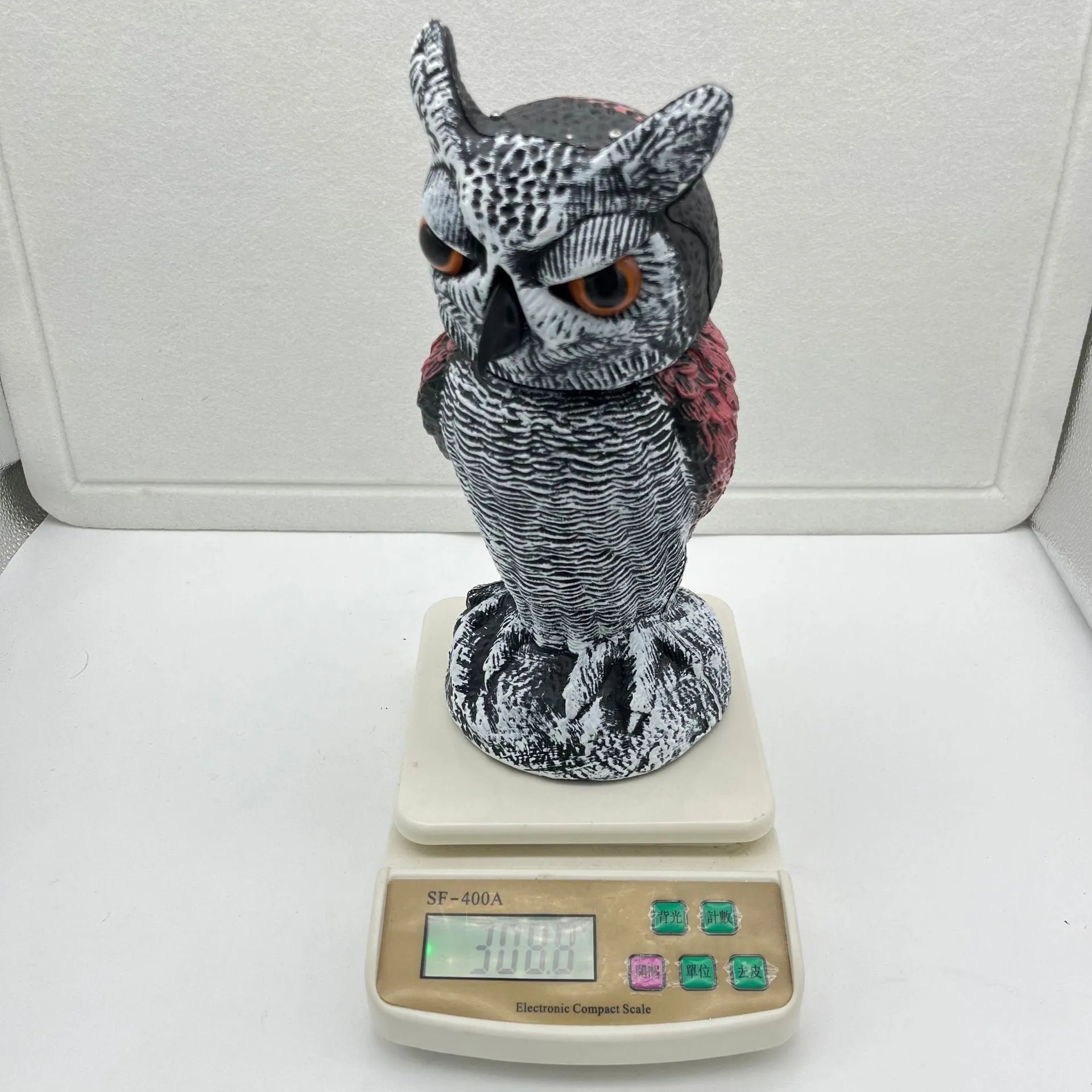 Artificial owl bait ornament with shaking head for garden bird deterrent in outdoor setting
