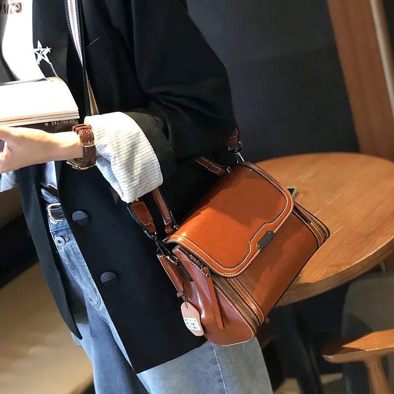 Women's brown genuine leather messenger bag with retro styling and multiple internal pockets