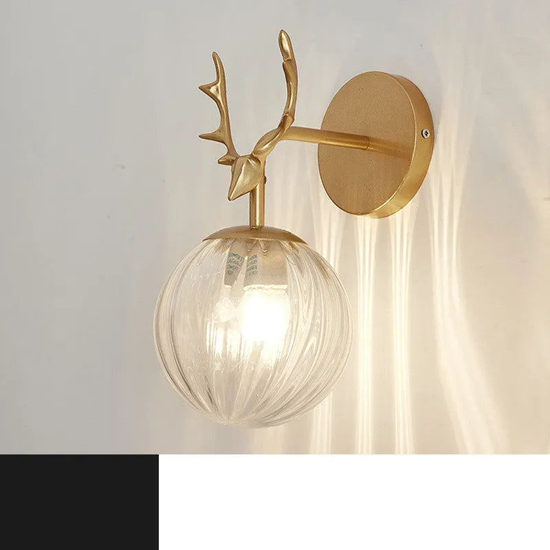 Nordic minimalist round glass wall lamp in golden finish mounted on a wall.
