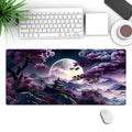 Large black gaming mouse pad with geometric pattern on a desk, shown with keyboard and mouse.