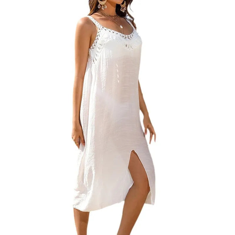 White suspender beach dress with woven crochet detail and a bottom slit, laid flat.