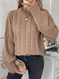 Women's loose beige casual sweater with round neck and twist detail on a hanger.