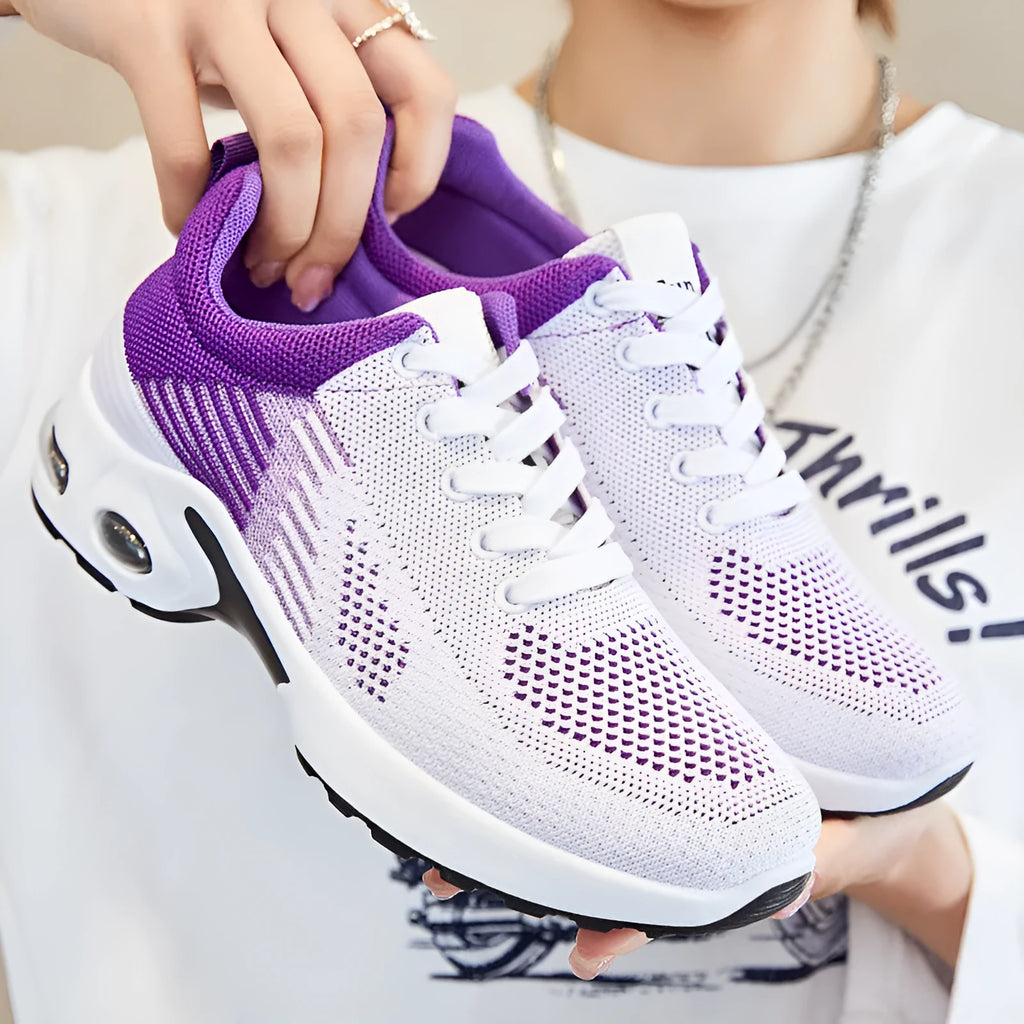 Women's Flyknit casual running shoes in striped pattern with lace-up front, shown in pink colour.