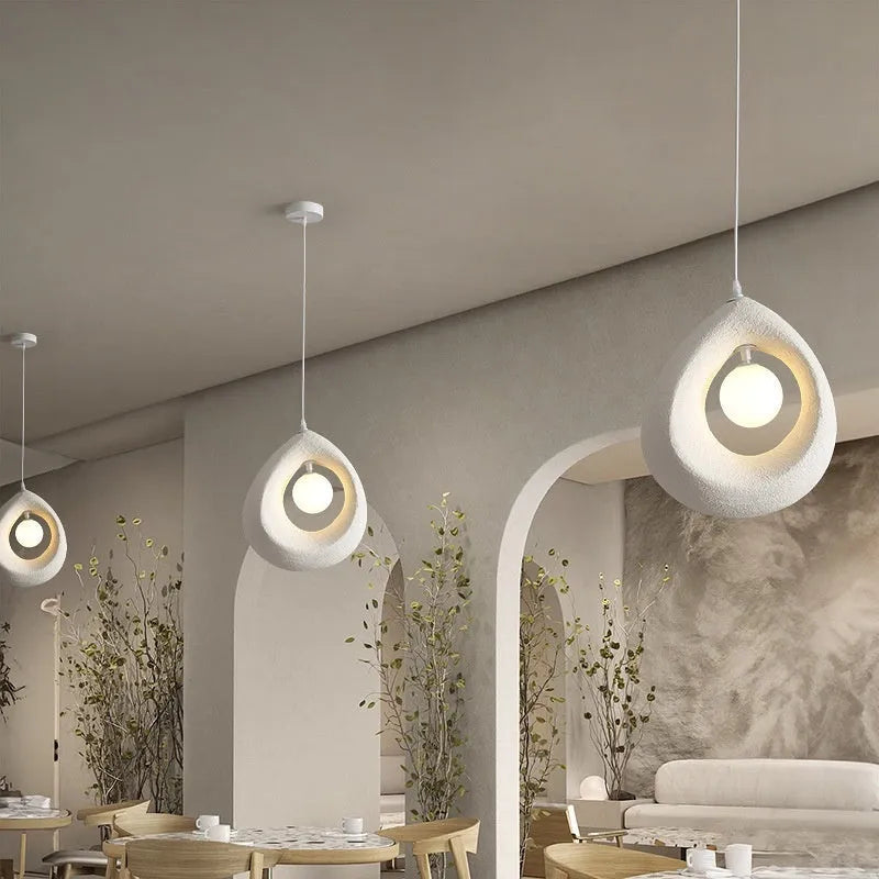 Sili Style modern pendant light with milky white glass shade in a dining room setting.
