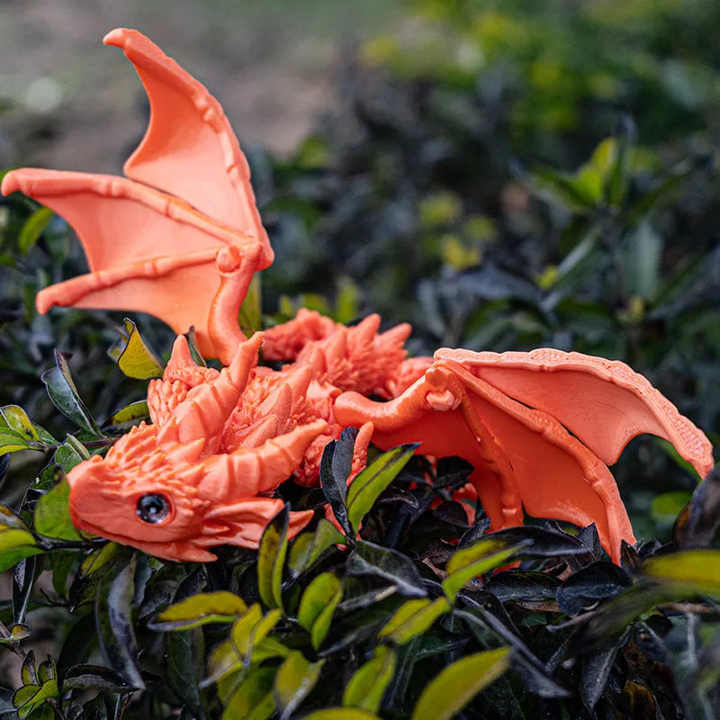 Red and gold 3D printed dragon wings toy decoration on a white background.