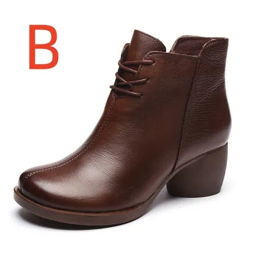 Women's black leather Martin boots with a thick middle heel and round toe on a white background.