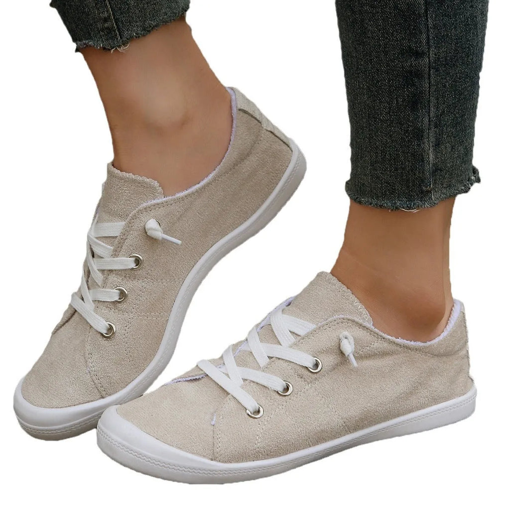 Women's creamy-white fabric casual sneakers with rubber soles shown in low-top design