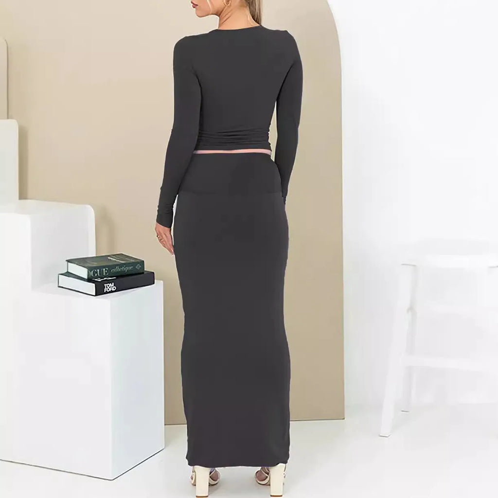Women's black slim fit two-piece suit set with three-quarter sleeve top and long skirt on a model.