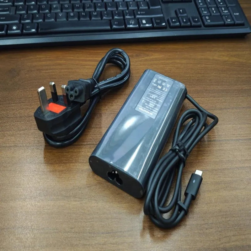 Black oval 65W USB-C laptop power adapter with Type-C port and multiple international power cords