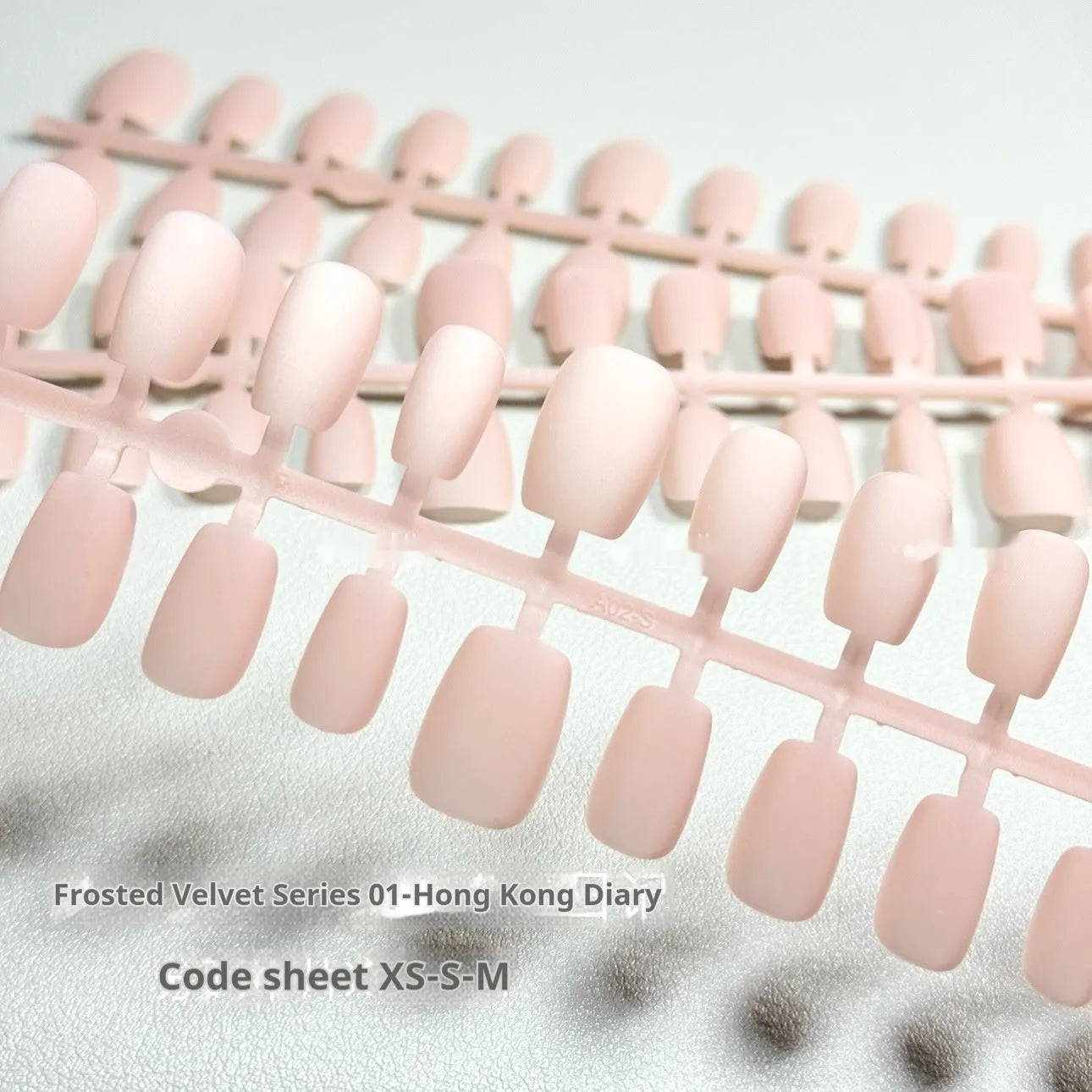 Set of frosted velvet Cat's Eye false nails with Aurora effect on a hand, showing short ladder XS, S, and M sizes.