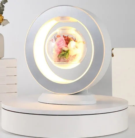 Floating heart LED night light with magnetic levitation displaying a red eternal flower on a desk
