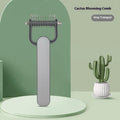 Green and grey dog hair unknotting comb with stainless steel teeth on a plastic handle.