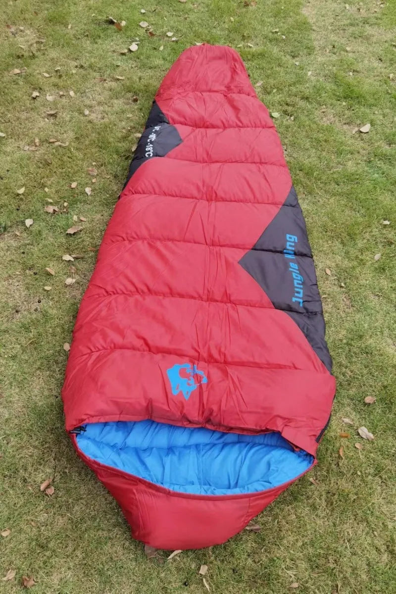 Outdoor cotton sleeping bag in army green, shown next to its grey compression storage sack