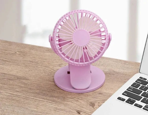 White USB clip fan with plastic blades mounted on desk edge showing piano button switch