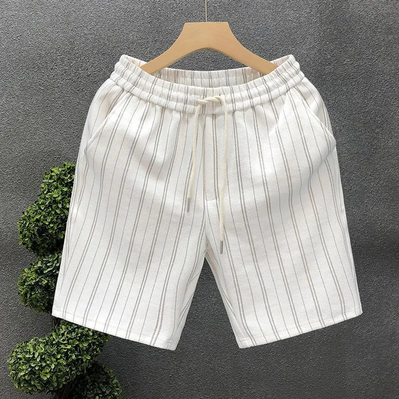 Man's black and white striped casual shorts with elastic waistband on a plain background.