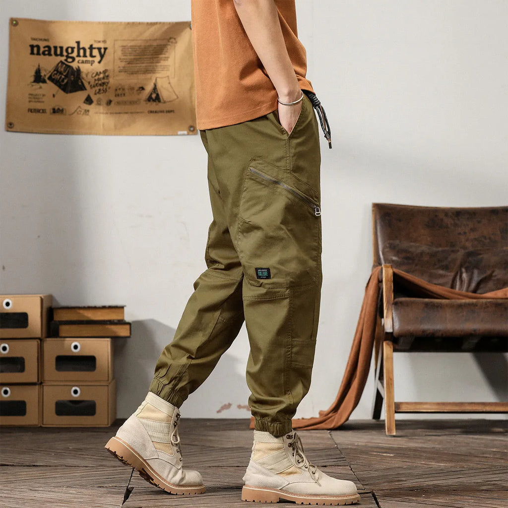 Men's loose khaki cotton harem trousers with tapered leg and ankle banding.