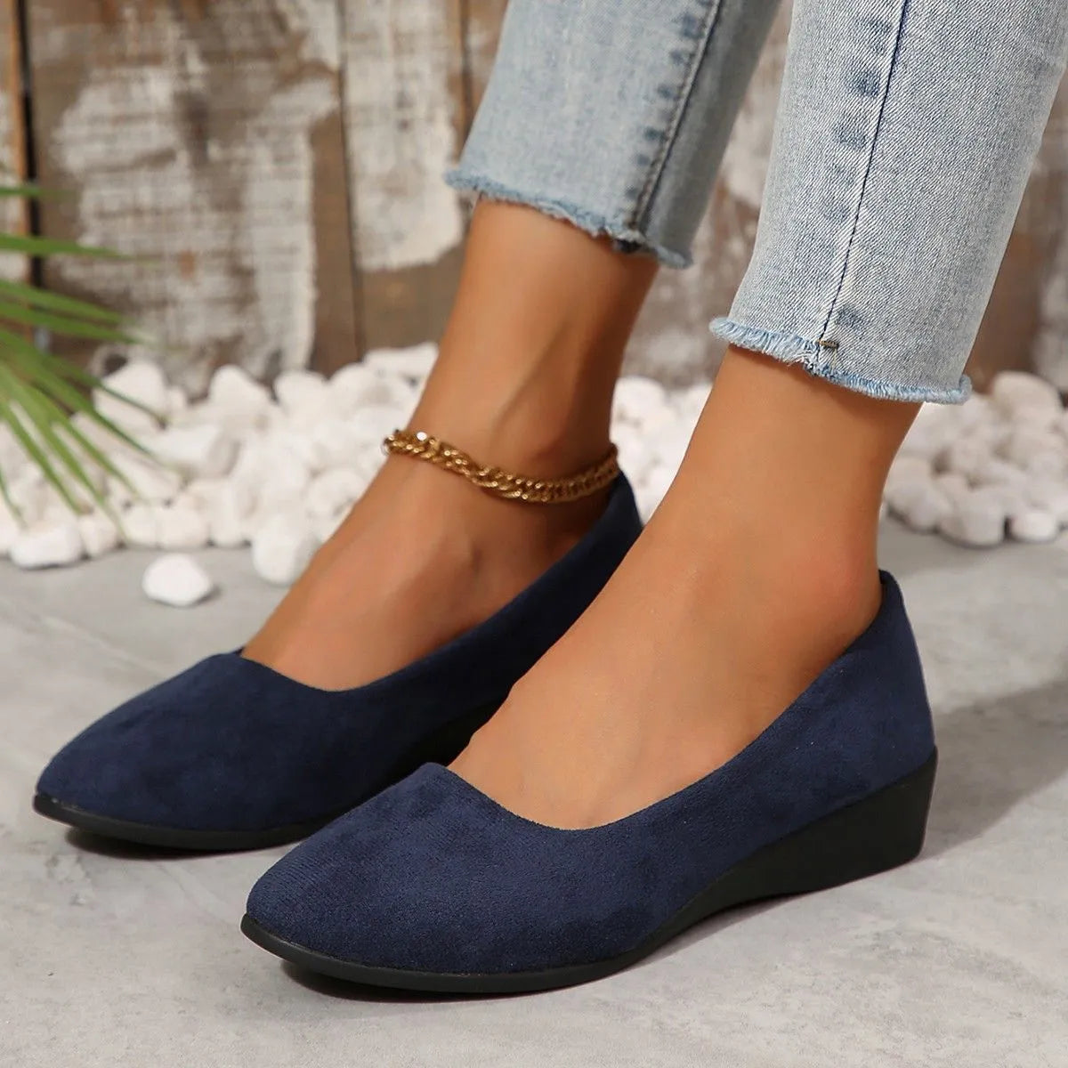 Women's suede wedge pump in light brown with a pointed toe and low rubber sole.