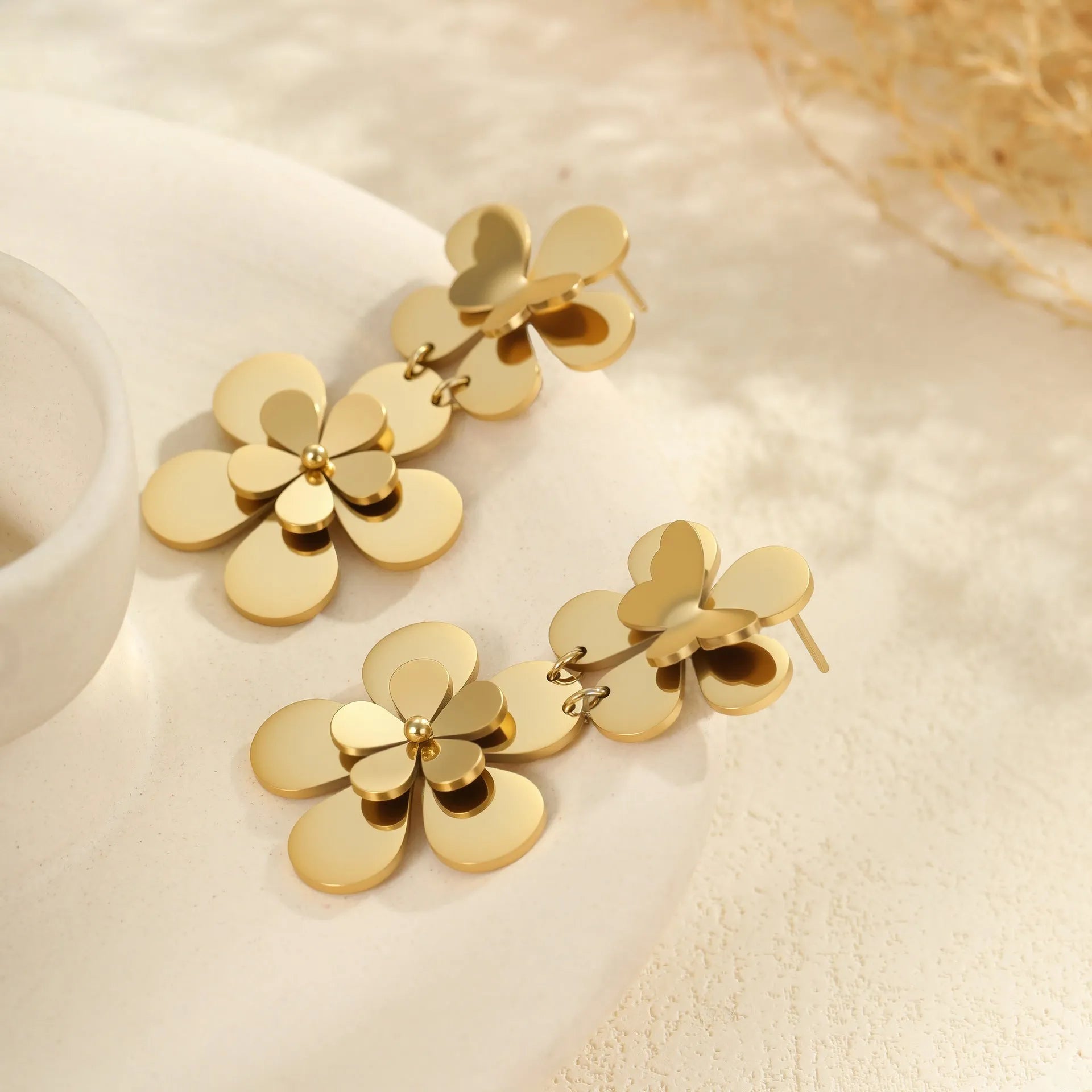Women's stainless steel earrings with 18K gold electroplated finish featuring floral butterfly and geometric zodiac design